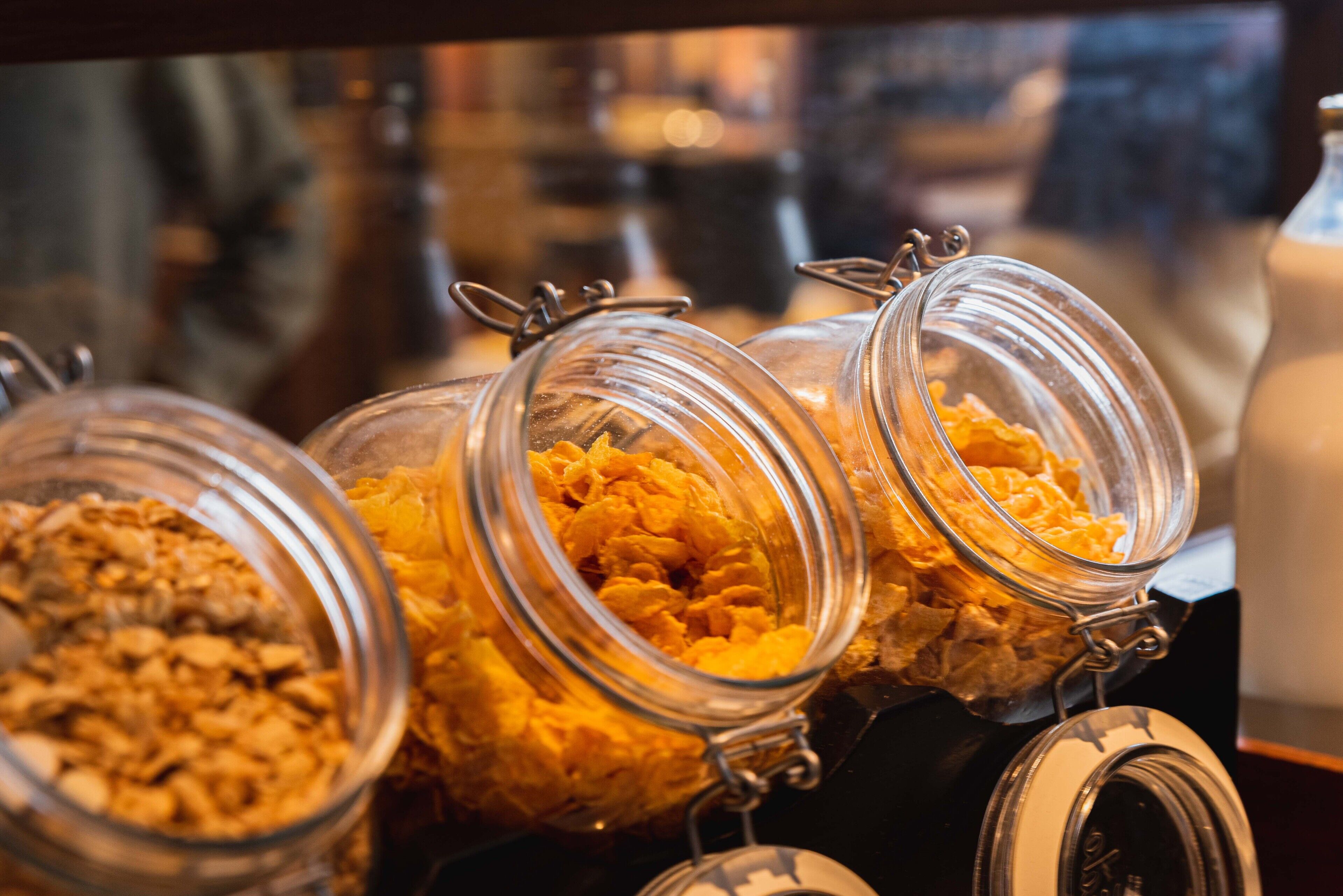 Três potes de vidro com fechos de metal contendo diferentes tipos de alimentos.
