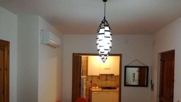 A compact kitchen with a dining area. - Casa Barchetta (Alghero)