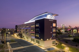 Un hotel moderno con techo plano, varios pisos y un llamativo letrero que dice 'HOTELES'.