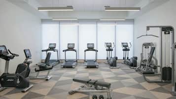 A gym with treadmills, elliptical machines, and free weights.