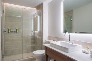 A modern bathroom with a glass-enclosed shower, a white sink, and a toilet. - Element by Marriott Denver Downtown East (Denver)