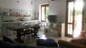 Een knus leefruimte met een keuken, eethoek en een televisie.