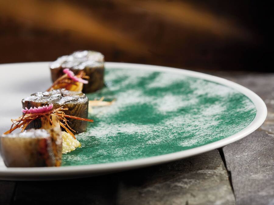 A plate with food items on a green and white plate.