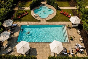 A rectangular swimming pool with a circular hot tub in the center, surrounded by lounge chairs and umbrellas. - StoneHaven Le Manoir Relais & Châteaux (Sainte-Agathe-des-Monts)