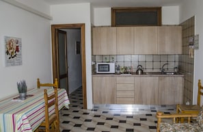 Departamento, 2 habitaciones | Cocina privada | Refrigerador, microondas, parrilla de estufa y cafetera y tetera 