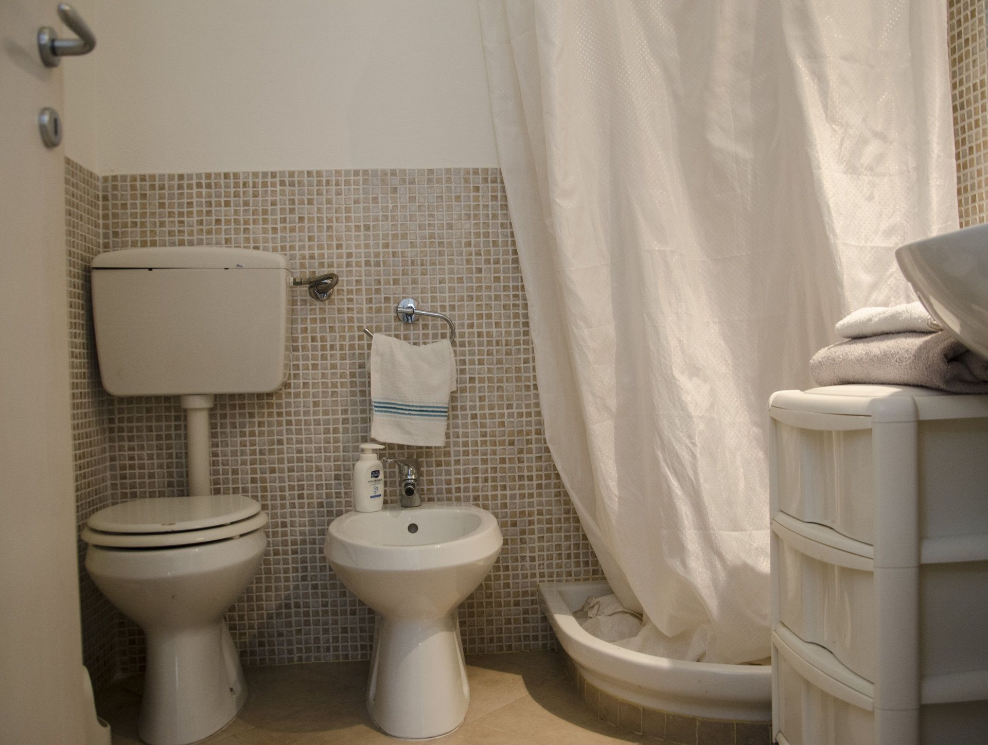 A bathroom with a toilet, bidet, and sink.