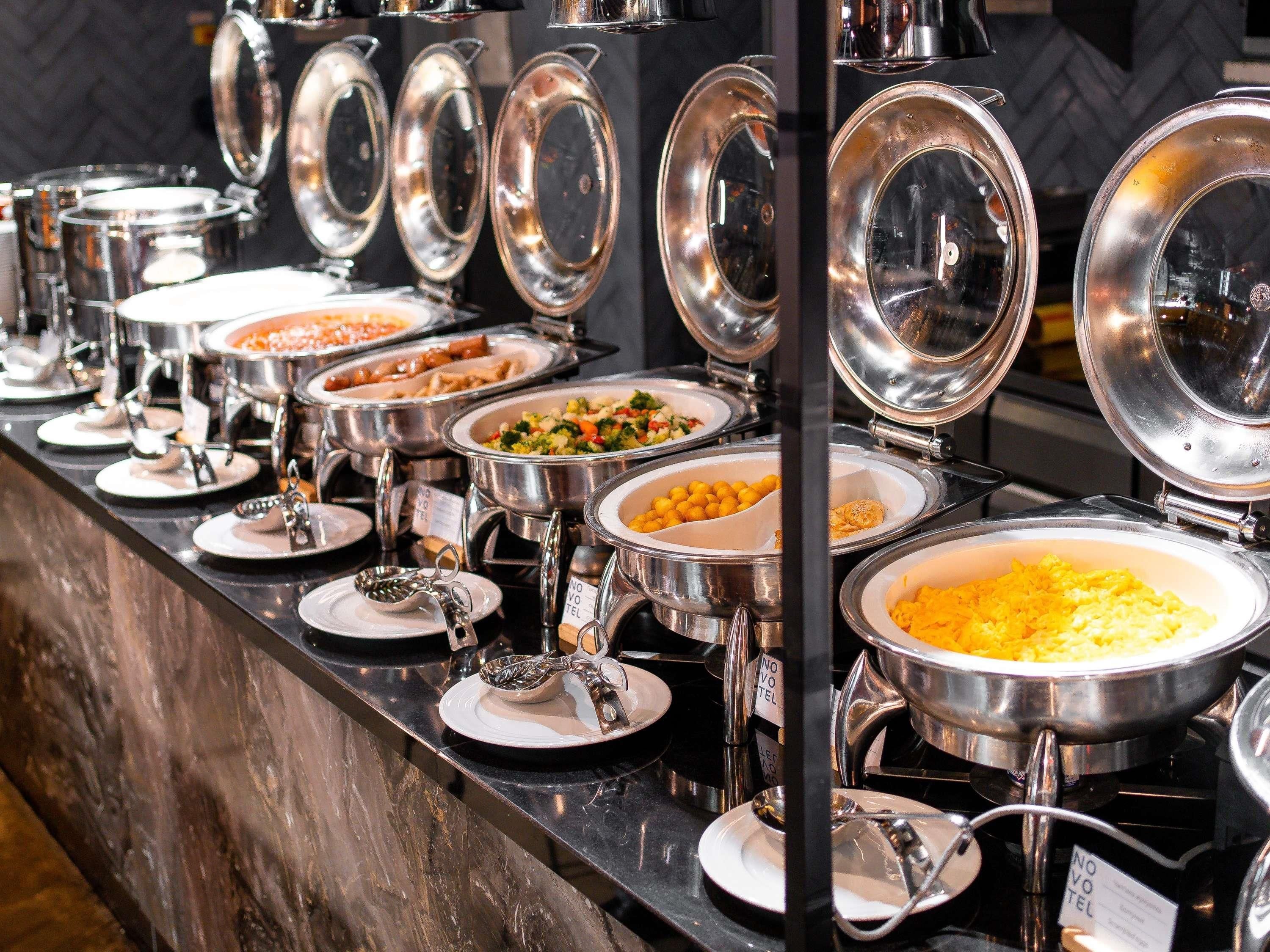 Ein Buffet mit verschiedenen Speisen in Metallservierbehältern, präsentiert auf einer Theke.