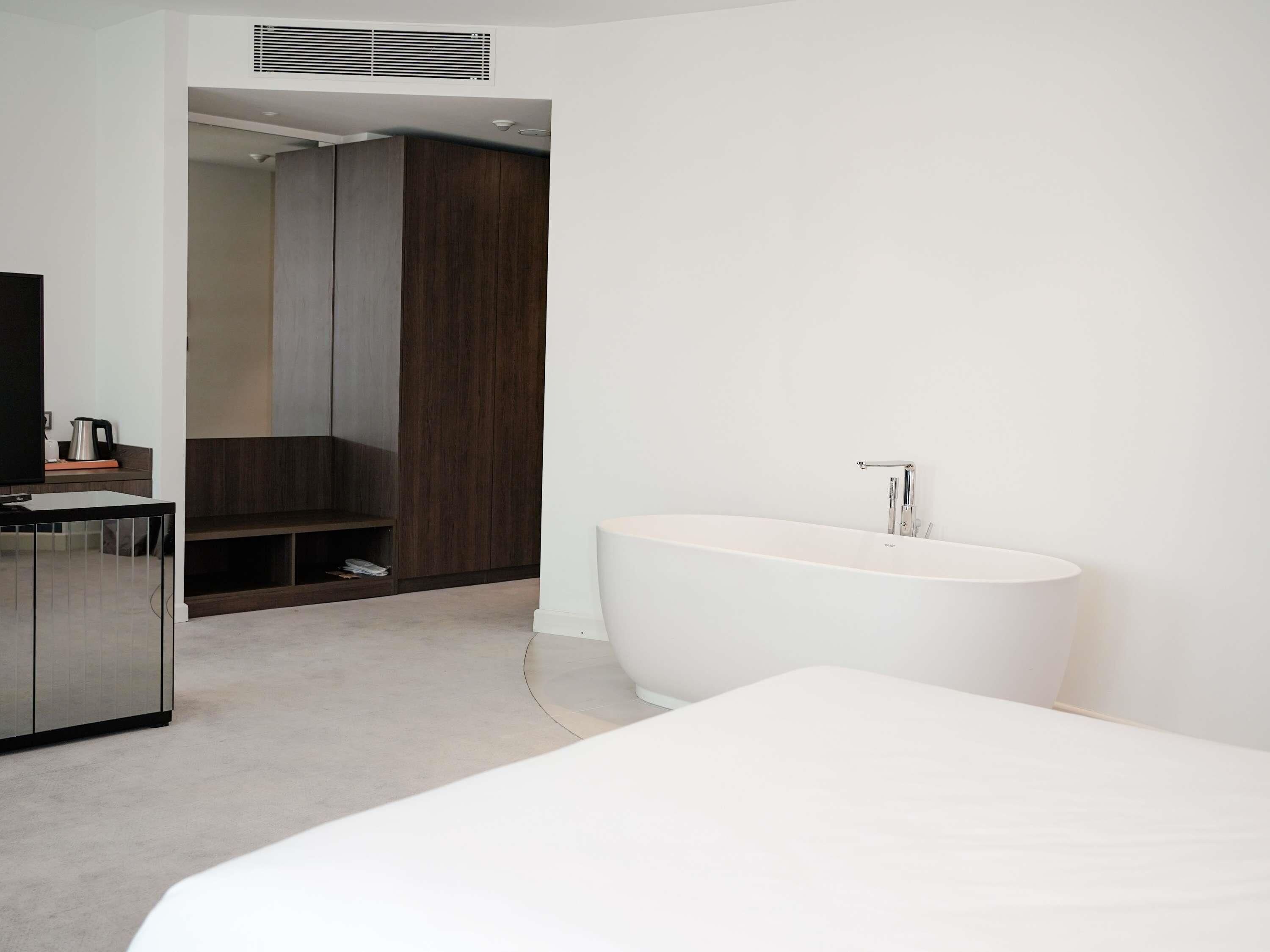 A modern bathroom with a freestanding bathtub, a vanity with a mirror, and a shower area.