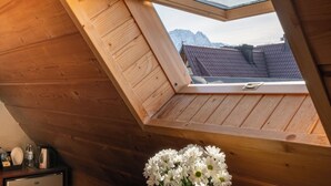 A wooden interior with a skylight, a wooden desk, and a vase of white flowers. - Willa u Anusia Jacuzzi & Sauna (Zakopane)