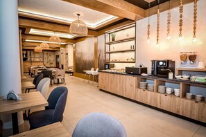 A modern cafe with wooden furniture, a counter with coffee machines, and hanging pendant lights. - Willa u Anusia Jacuzzi & Sauna (Zakopane)