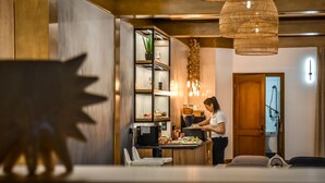 A modern kitchen with wooden cabinets, a black countertop, and a hanging light fixture. - Willa u Anusia Jacuzzi & Sauna (Zakopane)