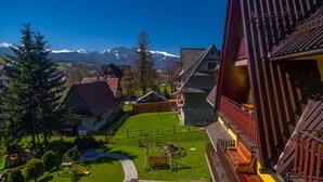 A residential area with a playground, a wooden fence, and houses with sloped roofs. - Willa u Zwijacza (Zakopane)
