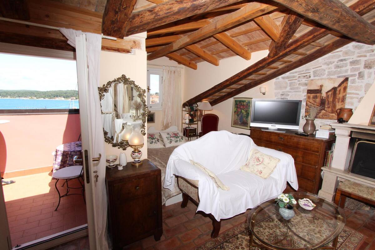 Una habitación acogedora con cama, televisión y vista al mar.