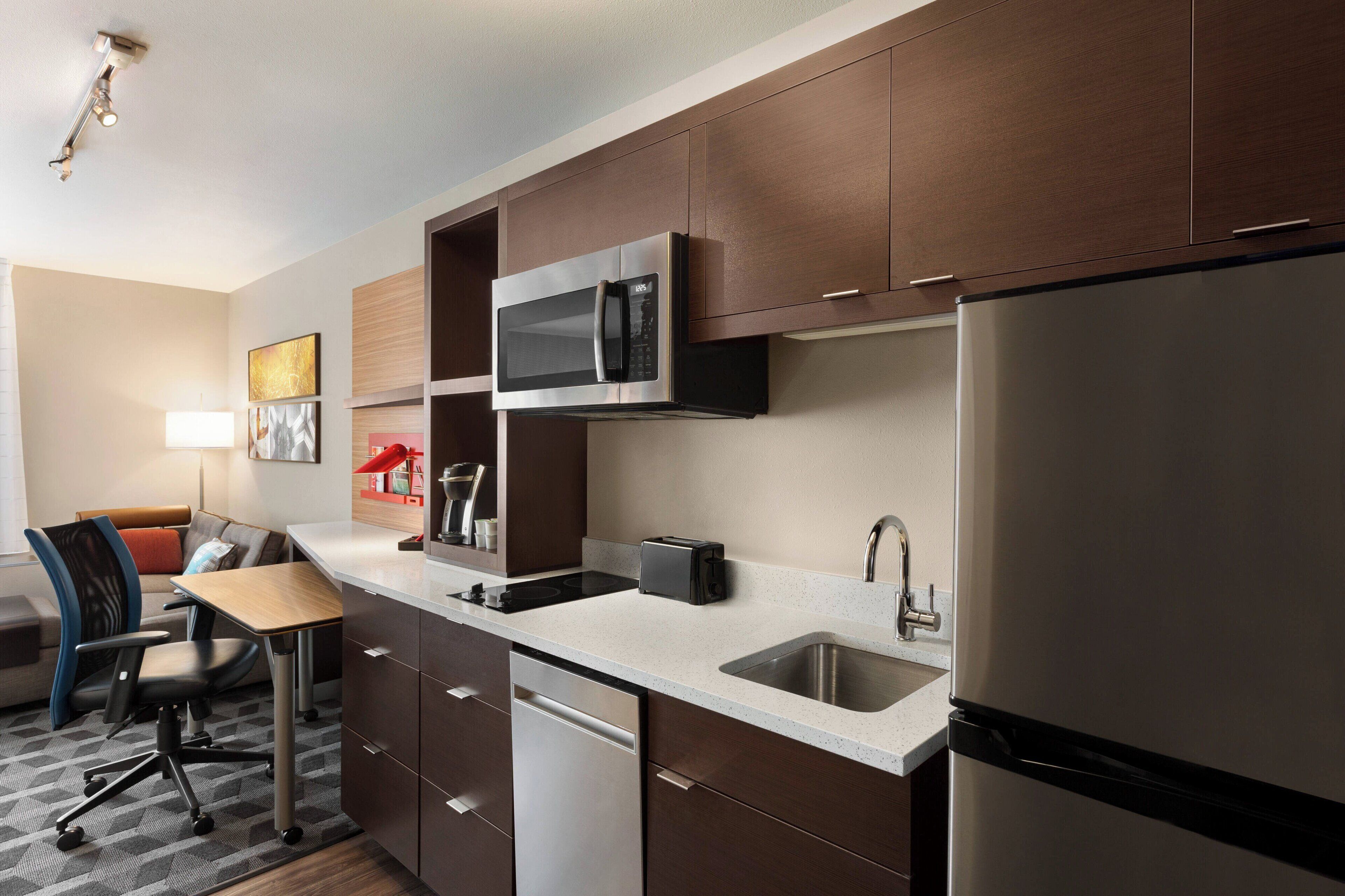 A compact kitchen with a microwave, toaster, and sink.