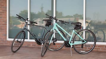 Dos bicicletas estacionadas frente a un edificio con grandes ventanales.