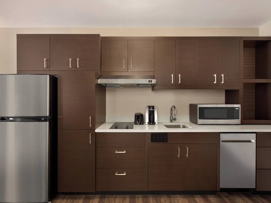A modern kitchen with stainless steel appliances, wooden cabinets, and a dishwasher.