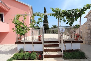 Stunning building entrance with a grand staircase and lush greenery.