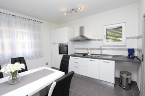 Enjoy cooking in this well-equipped kitchen with a stainless steel range hood, sink, and coffee machine.