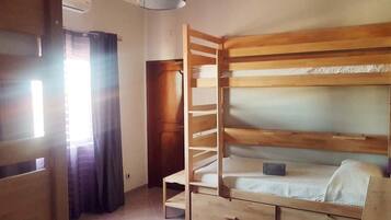 Un letto a castello con una scala, un comodino e un cassetto.