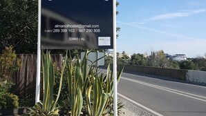 A sign for Almacil Hostel with contact information and a directional arrow. - Almancil Hostel (Loulé)