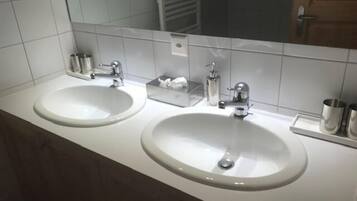 Ein Badezimmer mit zwei Waschbecken, einem Spiegel und einem Handtuchhalter.