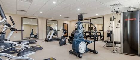 A gym with various exercise equipment including treadmills, an elliptical, and a weight machine.