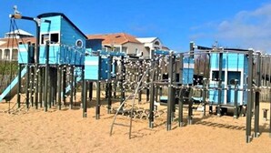 A beach playground with multiple play structures, including slides and climbing frames, set in sandy terrain. - Family Home Near Marais Girard Beach, Quiet Cul-de-Sac, 9 Sleeps, 2 Terraces, WiFi (Bretignolles-sur-Mer)