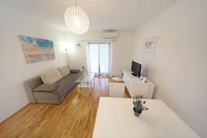 Appartamento, 1 letto queen con divano letto, vista mare | Soggiorno | TV a schermo piatto