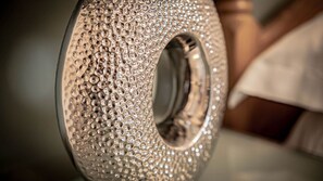 Un gros plan d’un objet métallique à la surface texturée, doté d’un trou central.