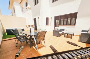 A patio area with a table and chairs, a sofa, and a small table. - RONDA HOME, BEAUTIFUL MODERN HOUSE + WIFI (Ronda)
