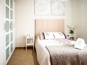 A bedroom with a bed, nightstands, a wardrobe, and decorative wall art. - RONDA HOME, BEAUTIFUL MODERN HOUSE + WIFI (Ronda)