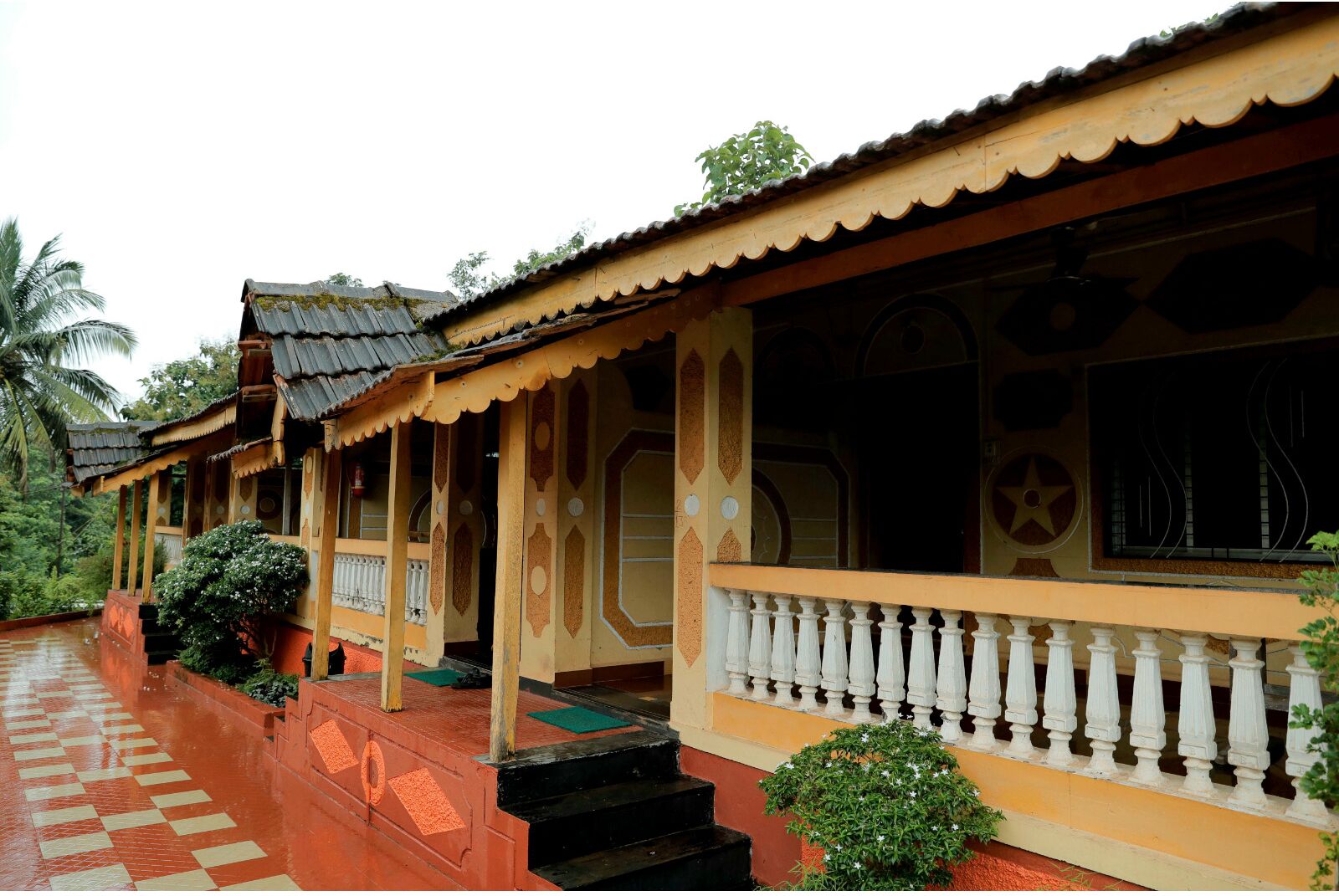 A traditional building with a tiled walkway, a balcony with a balustrade, and a star symbol on the wall.