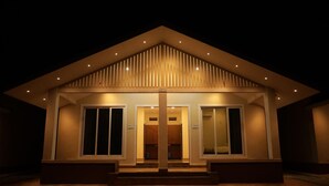 Un bâtiment moderne doté d’un toit en pente et d’une entrée centrale.