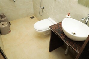 Un baño con inodoro, lavabo y ducha.