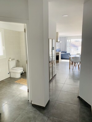 Une salle de bain moderne avec des toilettes, un espace douche et un tapis sur le sol.
