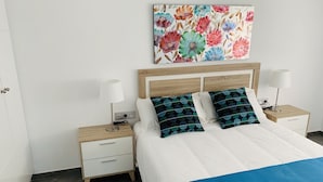 Una camera da letto con un letto, due comodini, un tavolino e un quadro appeso al muro.