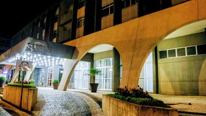 A hotel entrance with a modern design, featuring large arched structures and a well-lit facade. - Susin Hotel (Mafra)