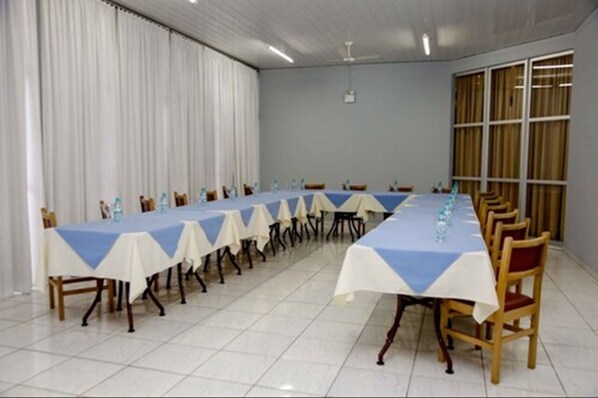 A conference room with a long table set for meetings, equipped with chairs and water bottles.