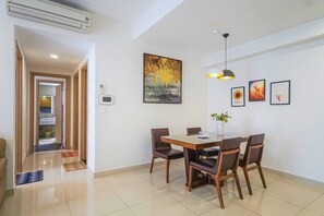 Uma área de refeições com mesa, cadeiras e luminária pendente.