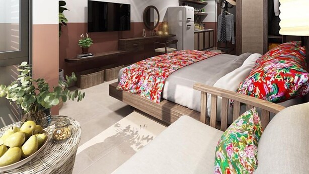 Un dormitorio moderno con cama, mesitas de noche, un espejo, armario y una pequeña kitchenette.