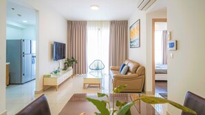 Una sala moderna con sofá, televisión y comedor.