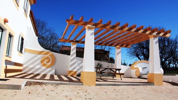 Un espace extérieur abrité, doté d’une pergola, de bancs et d’une table de pique-nique.