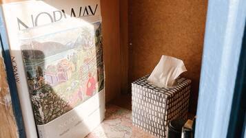 A small room with a map on the floor, a tissue box, and a book titled 'NORWAY'.