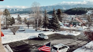 A parking lot with two cars and an American flag. - Northside School B&B (Bonners Ferry)