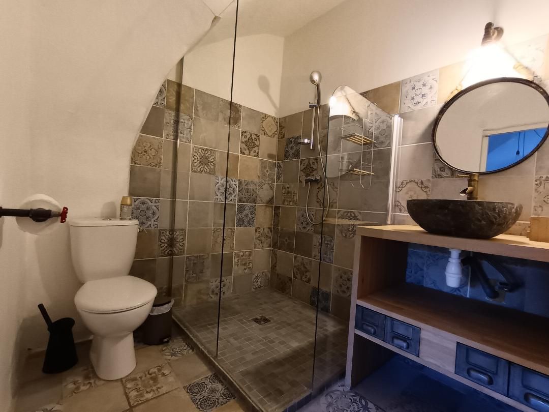 Ein Badezimmer mit Toilette, Duschkabine und Waschbecken mit Spiegel.