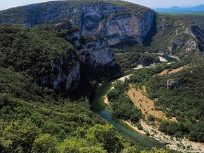 A river winding through a mountainous landscape with dense vegetation and rocky cliffs.