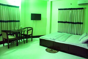 A room with a bed, a desk, and a chair. - Tony's Place (Sreemangal)