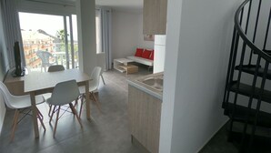 Eine moderne Wohnung mit Essbereich, Küche und einer Treppe.