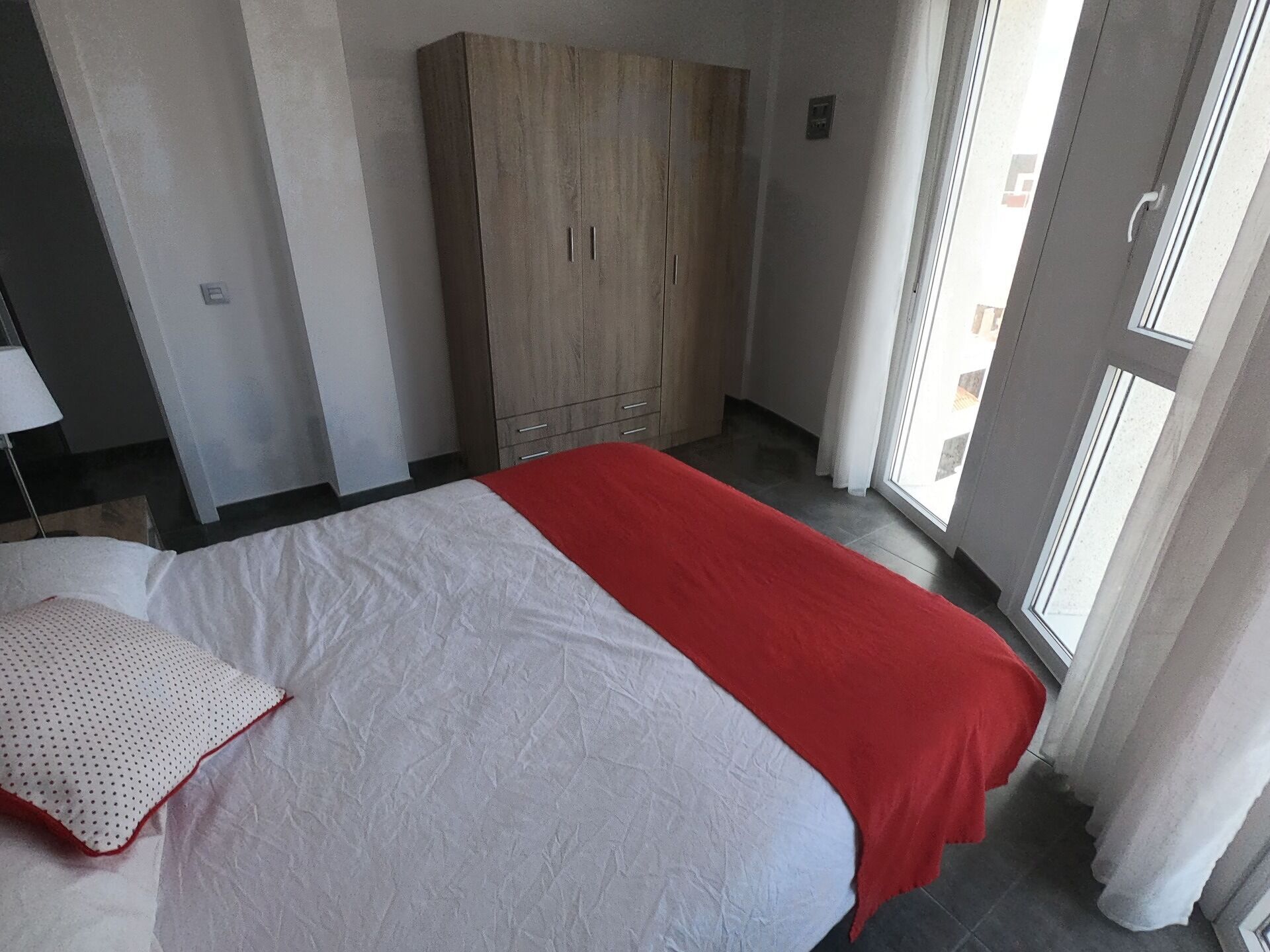 Habitació d'hotel amb un llit, un armari i una finestra.