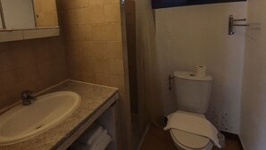 Une salle de bain équipée d’un lavabo, de toilettes et d’un porte-serviettes.